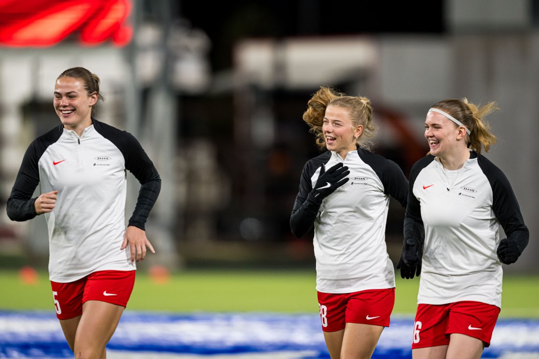 På tross av å stå ovenfor tidenes utfordring, var det også smil å se blant Brannspillerne under oppvarmingen på Åsane Arena forrige onsdag. Marthine Østenstad, Justine Kielland og Signe Gaupset må opp enda noen hakk i returoppgjøret i Barcelona i kveld. Foto: Marius Simensen/Bildbyrån